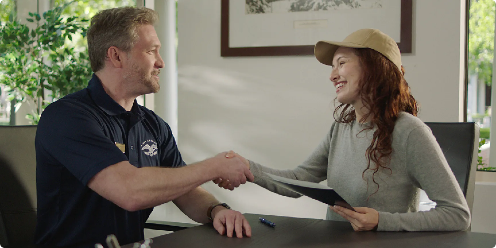 Customer and agent smiling while walking through an office.